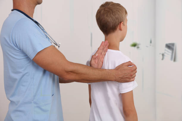 Child having chiropractic back adjustment. Osteopathy, Physiotherapy, Kinesiology. Bad posture correction stock photo