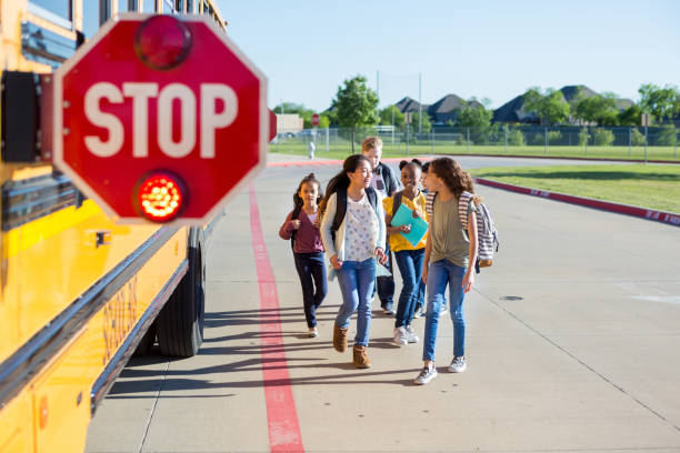 istock Children walk safely while bus stop sign is flashing 1158890065