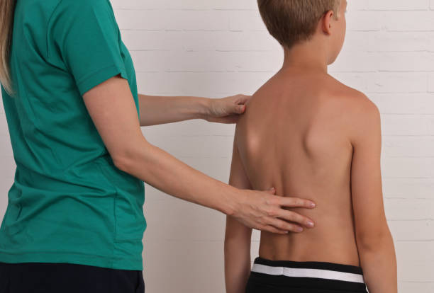 istock Child having chiropractic back adjustment. Osteopathy, Physiotherapy, Kinesiology. Bad posture correction 1158890090