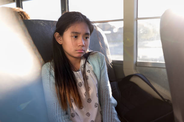 On bus, young girl is sad after a hard day On the bus home from school, the young elementary school girl is sad after a hard day. asian academic anxiety stock pictures, royalty-free photos & images