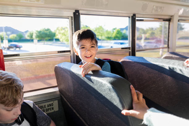 istock On bus, young boy looks at unseen friend 1158890133