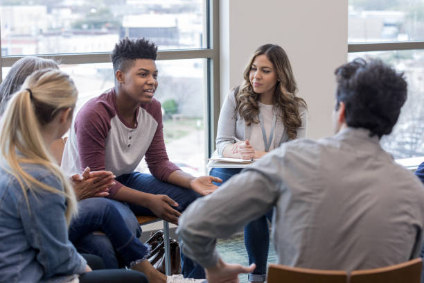 in terapia, teen boy condivide esperienze di vita con il gruppo - discussion women circle therapy foto e immagini stock