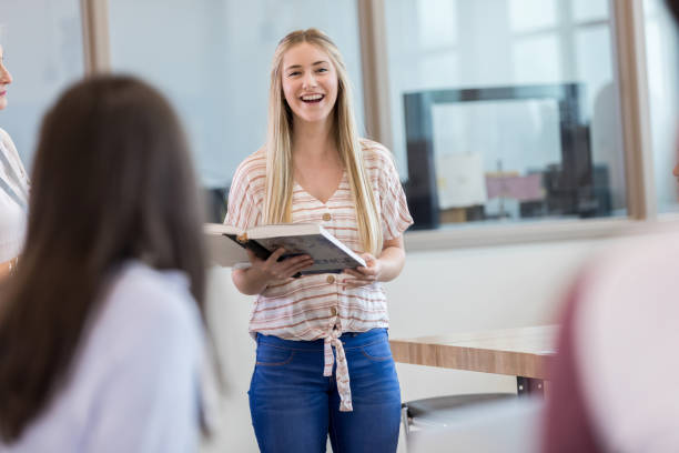 Teen girl laughs while presenting her report to science class