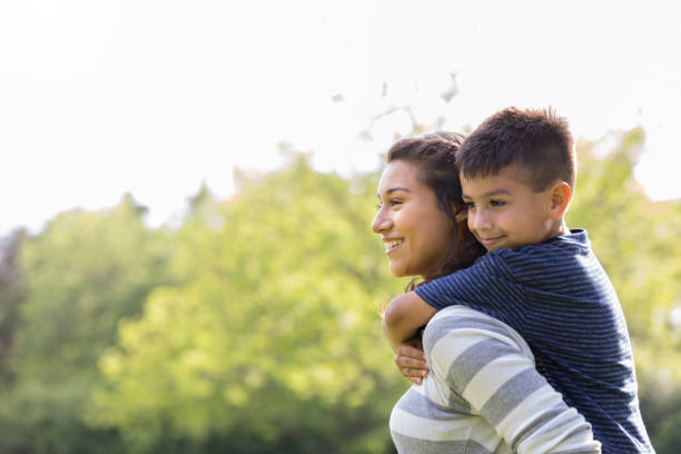 istock Young woman bonds with elementary age brother 1158890262