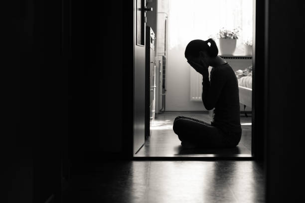 Woman feeling sad and desperate Young woman sitting on floor expressing sad feelings and emotions head in hands stock pictures, royalty-free photos & images