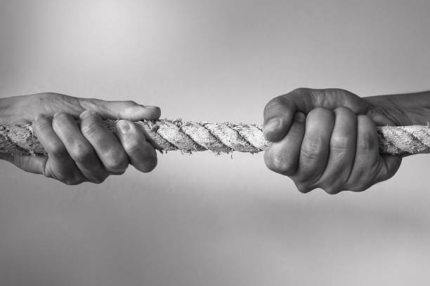 Hands pulling rope playing tug of war People competitive, dispute, contest concept. pulling stock pictures, royalty-free photos & images