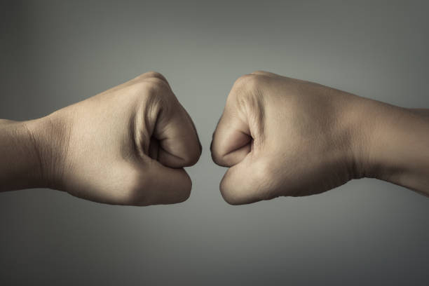 istock Clash of two fists coming together. 1158891020