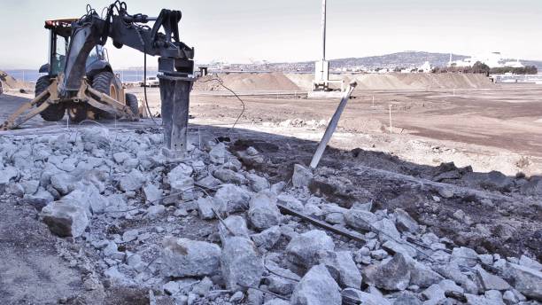istock Backhoe with a breaker attachment breaking up concrete to remove rebar 1158891412