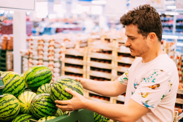 istock Young Man Buying Watermelon From Market 1158893818