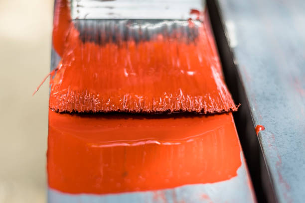istock a professional man is painting red color by a bush 1158894411