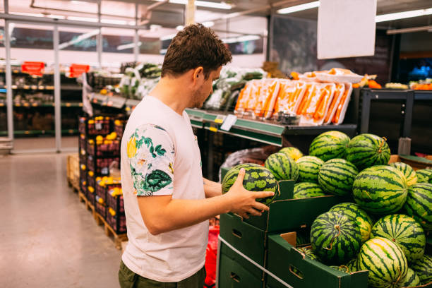 istock Young Man Buying Watermelon From Market 1158894711