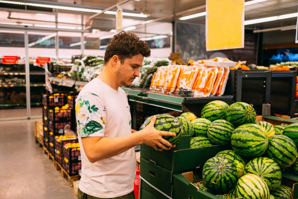 istock Young Man Buying Watermelon From Market 1158894744