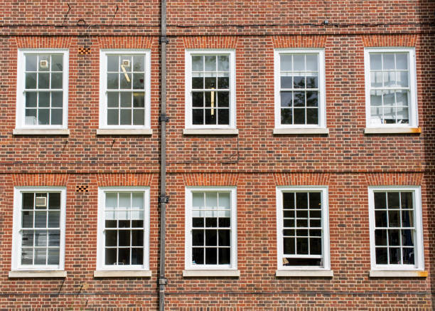 istock Eight windows with white sash and frame on a red brick wall Georgian British style 1158897321