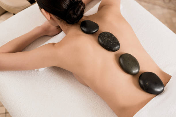 istock back view of woman getting stone massage at spa 1158898421