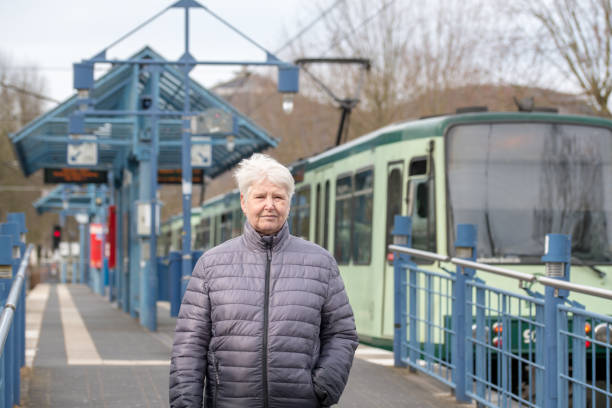 istock older woman and tram stop 1158898652