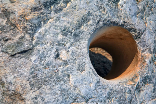 The texture of a large natural stone with a through hole close-up.