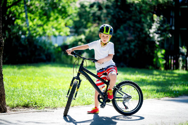 istock Little boy riding bicycle in the public park 1158901710