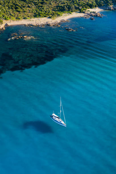 blick von oben, atemberaubende luftaufnahme eines segelbootes, das auf einem wunderschönen türkisklaren meer schwimmt. maddalena-archipel-nationalpark, sardinien, italien. - insel caprera stock-fotos und bilder