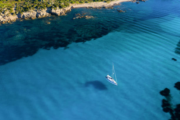 blick von oben, atemberaubende luftaufnahme eines segelbootes, das auf einem wunderschönen türkisklaren meer schwimmt. maddalena-archipel-nationalpark, sardinien, italien. - insel caprera stock-fotos und bilder