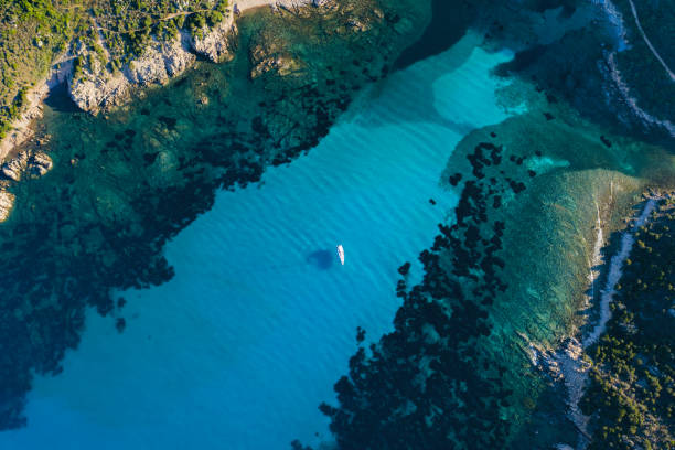 blick von oben, atemberaubende luftaufnahme eines segelbootes, das auf einem wunderschönen türkisklaren meer schwimmt. maddalena-archipel-nationalpark, sardinien, italien. - insel caprera stock-fotos und bilder