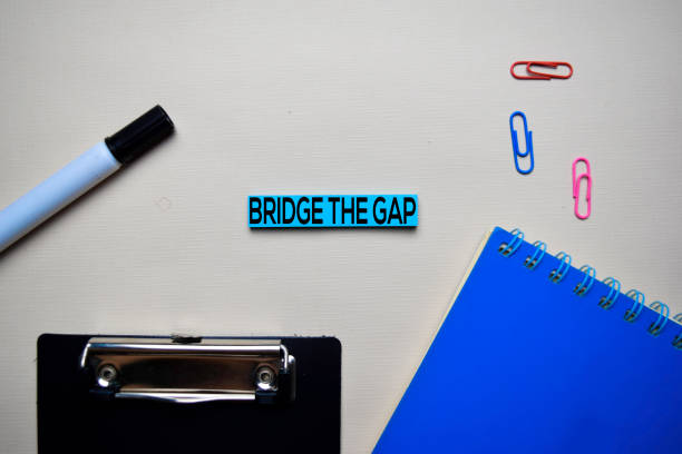 istock Bridge the Gap text on sticky notes with office desk concept 1158906479