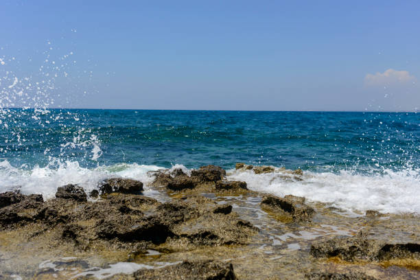 istock splashing waves crashing against a stone beach 1158906795