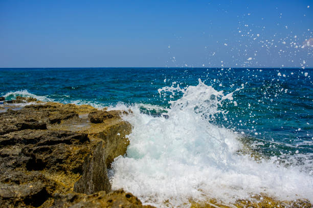 splashing waves crashing against a stone beach