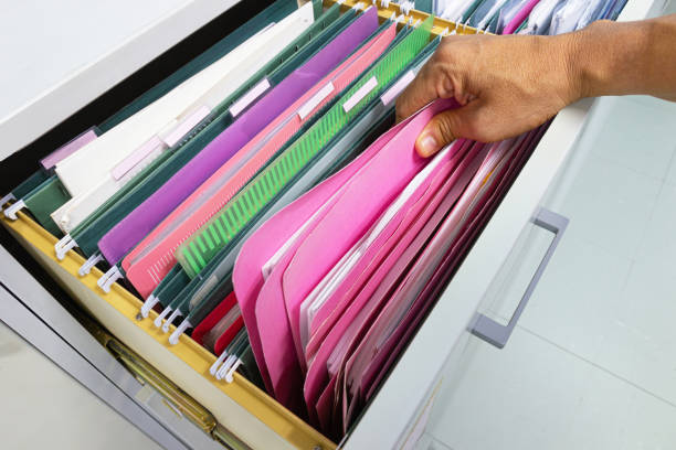 istock Hand of Man Search files document in a file cabinet in work office 1158910921