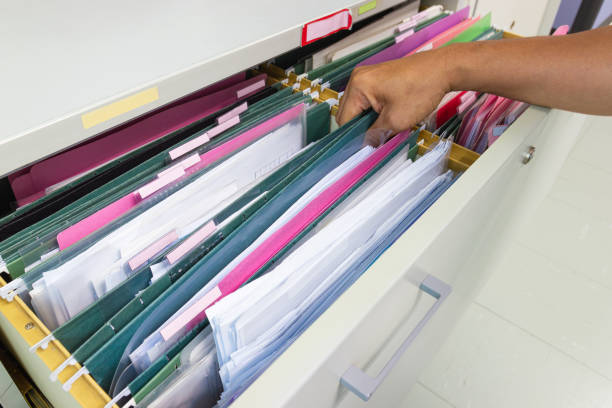 istock Hand of Man Search files document in a file cabinet in work office 1158910952