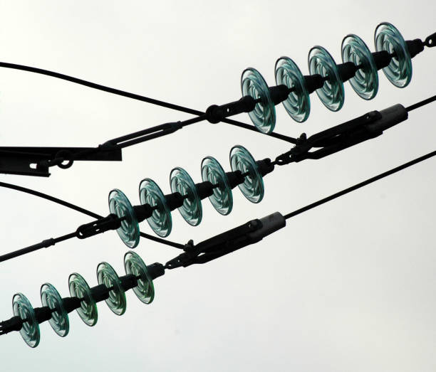 Three glass electrical insulators on a high voltage line.