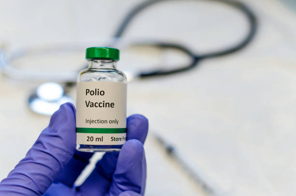 Polio vaccine vial holding in doctors hand Poliomyelitis virus vaccine with stethoscope and syringe at the background polio virus photos stock pictures, royalty-free photos & images