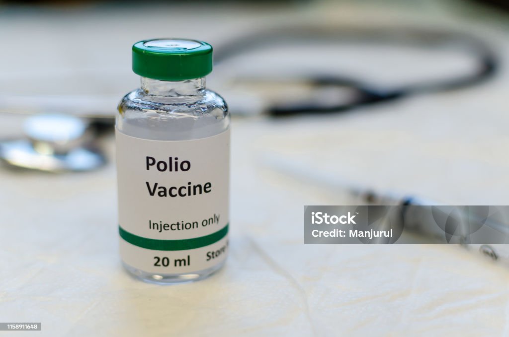 Poliomyelitis virus vaccine vial Polio vaccine vial with syringe and stethoscope at the background Polio Stock Photo