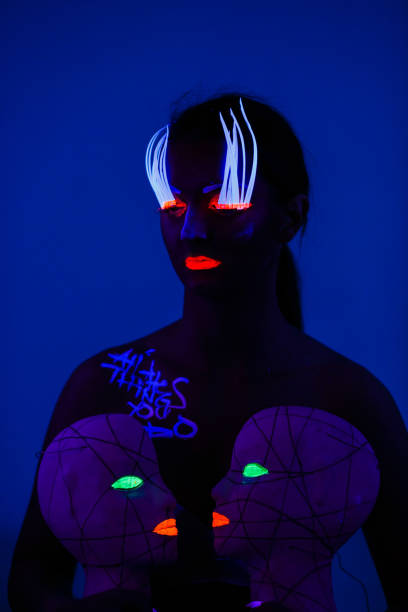 istock One woman painted with fluorescent make up holding abstract masks. 1158912758