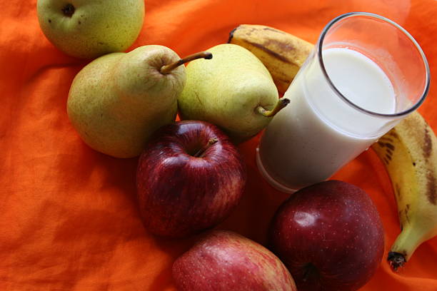 Glass of homemade apple juice with a red apple