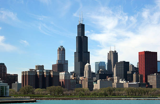 Chicago skyline on a clear day Chicago Skyline with Sears Tower and other skyscrapers as well as the Grant Park and turquoise waters of Lake Michigan under rather uncommon shaped clouds. willis tower stock pictures, royalty-free photos & images