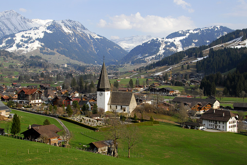 View on Saanen,a municipality in the canton of Bern,Switzerland.In the background the village of Gstaad,a famous skiing resort.