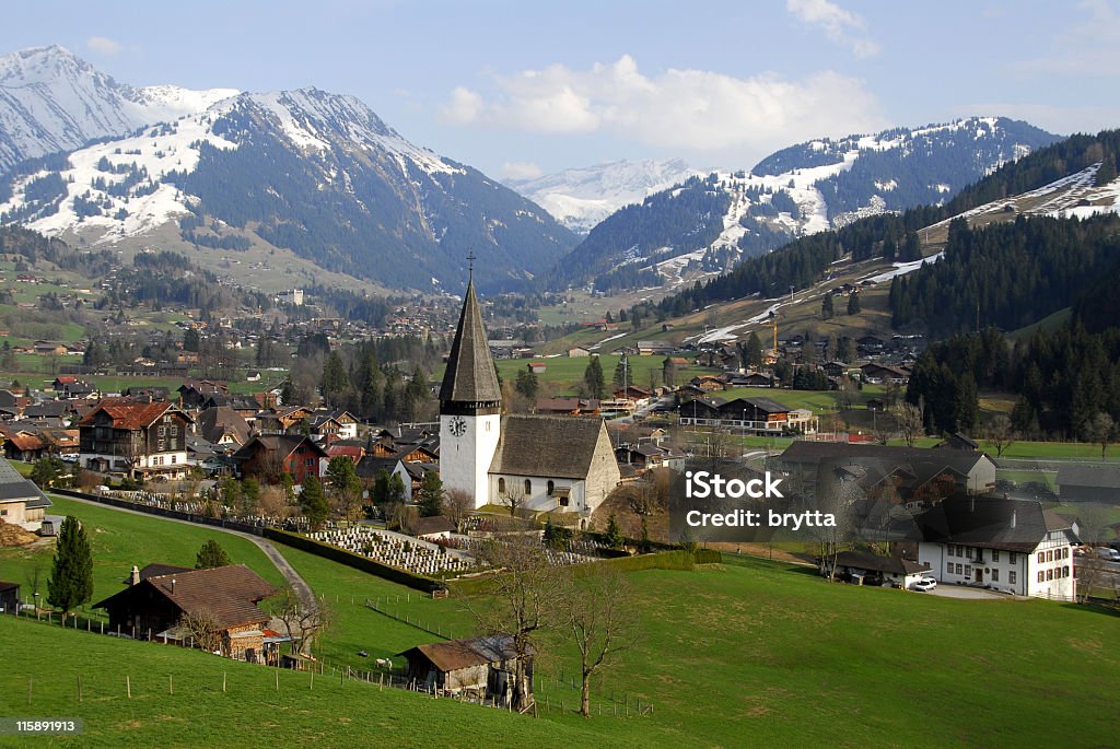 Swiss scenery in spring View on Saanen,a municipality in the canton of Bern,Switzerland.In the background the village of Gstaad,a famous skiing resort. Gstaad Stock Photo
