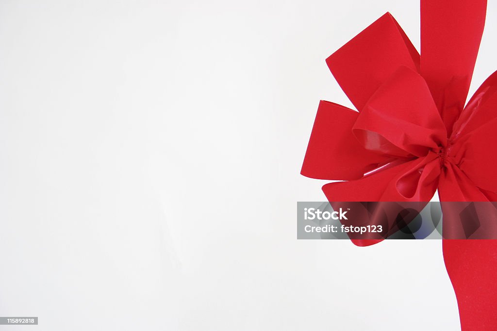 Big red bow. Right side. Isolated on white background. Copyspace. Big RED velvet bow on the right side of the page.  Left open for your text or picture.  Just add TO and FROM and you have a gift tag suitable for any occasion. Close-up Stock Photo
