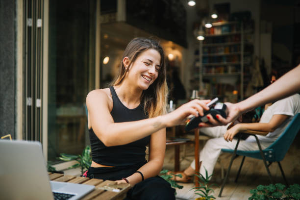 Young girl relaxing in a cafe, paying for drinks