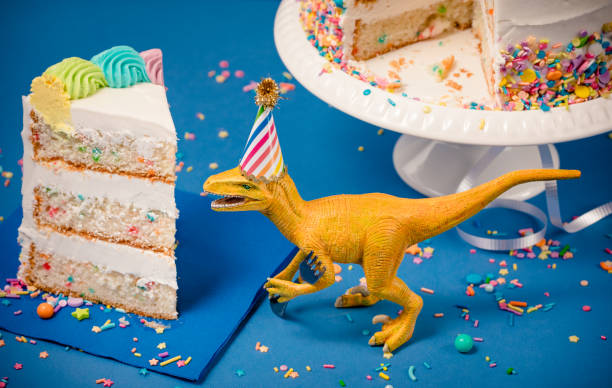 istock Dinosaur and slice of Birthday Cake 1158948428