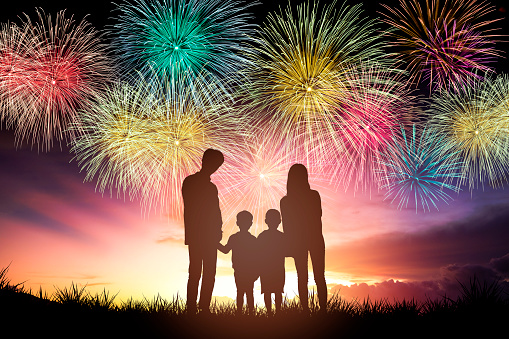 happy family standing and watching the fireworks