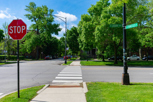 Street Intersection on Logan Boulevard and Francisco Avenue in Logan Square Chicago A street intersection with a stop sign and green grass and trees on Logan Boulevard and Francisco Avenue in the Logan Square neighborhood of Chicago boulevard photos stock pictures, royalty-free photos & images
