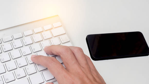 istock fingers are pressing enter the keyboard on white table. 1158968428