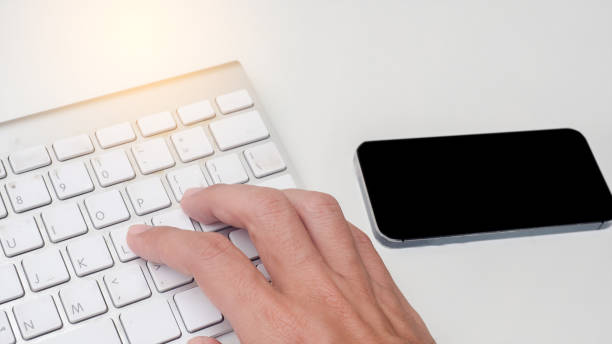 istock fingers are pressing enter the keyboard on white table. 1158968429