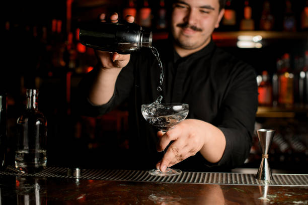 istock Bartender pours an alcohol from shaker to glass 1158970629