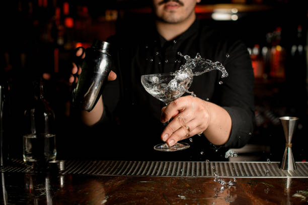 istock Bartender shaking alcohol in glass at counter 1158970724