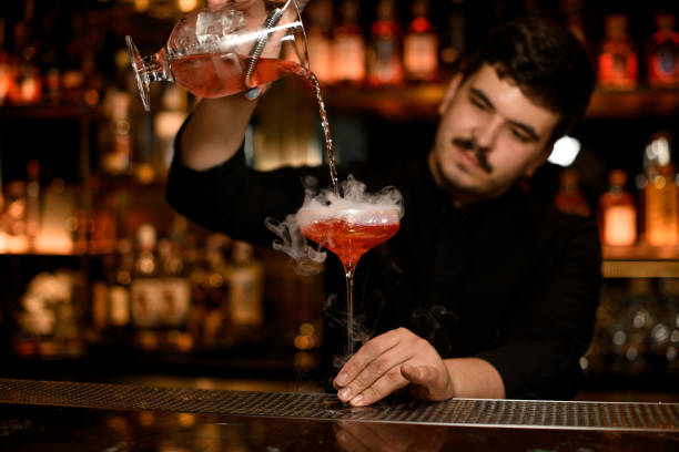 istock Bartender with strainer prepares an alcohol cocktail 1158971412