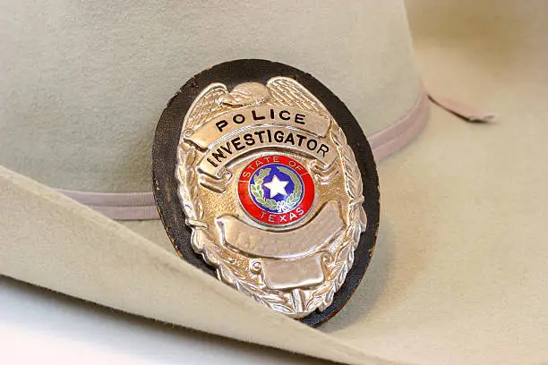 Police Investigator badge from Texas resting on a cowboy hat.