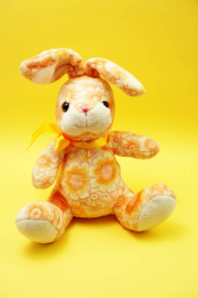 istock cute easter bunny rabbit plush doll Sitting on yellow background 1158973340