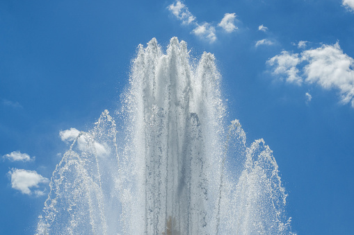 Splashes of the fountain against the blue sky